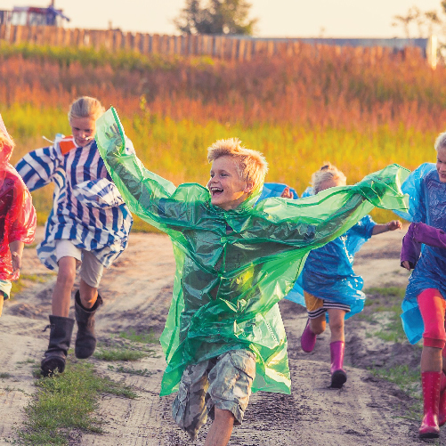 A group of children running on a dirt road

Description automatically generated