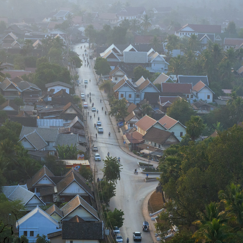 A high angle view of a street with houses and trees

Description automatically generated